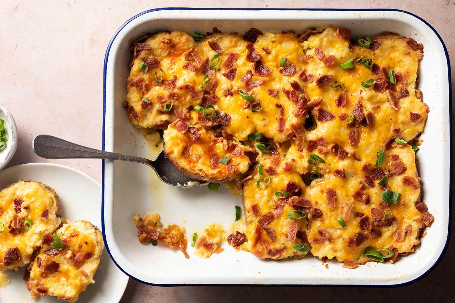 A cheesy potato casserole baking on the middle oven rack with a golden topping and bubbling edges visible in the pan
